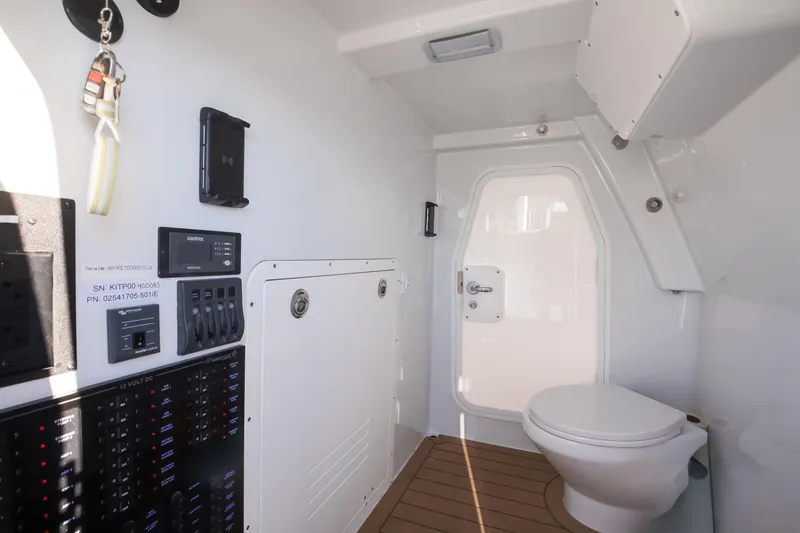 Slide: The Image of Interior of 2025 Freeman 43 Center Console boat featuring a modern bathroom and control panel. - 14