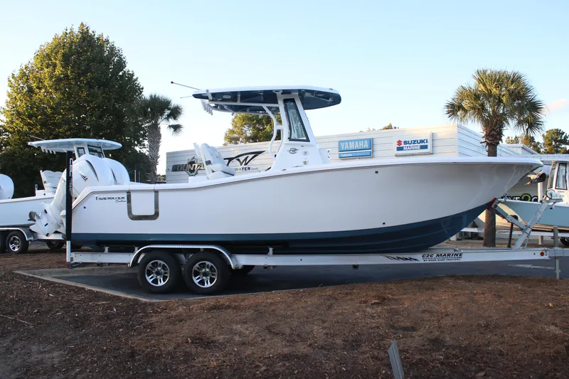 Slide: The Image of 2026 Tidewater 272 CC Adventure boat on trailer, parked outdoors near palm trees. - 18