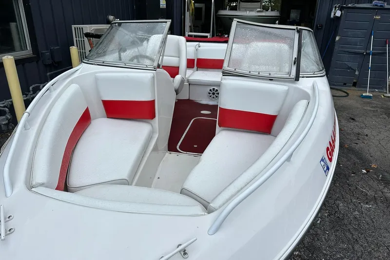 Slide: The Image of 1991 Chris-Craft 167 Concept boat with red and white interior, docked outdoors. - 2