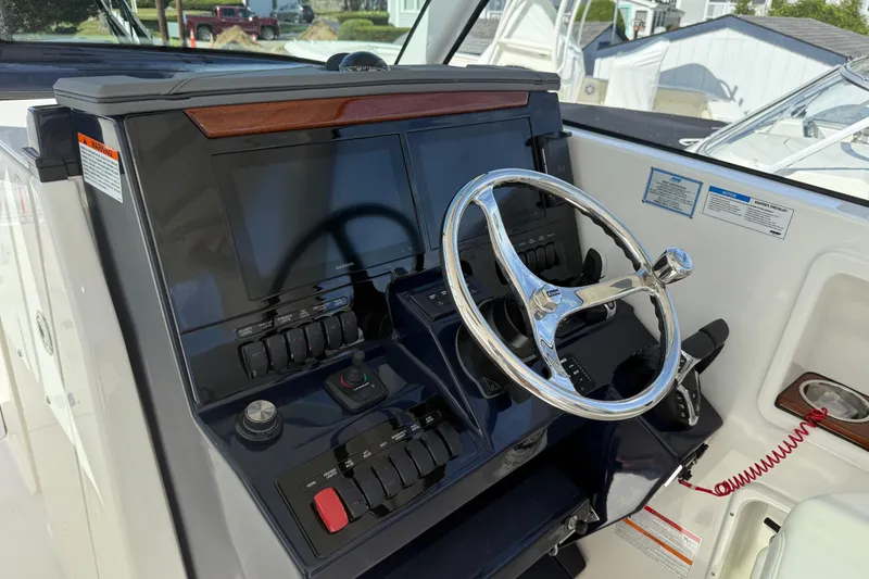 Slide: The Image of 2026 Pursuit DC 306 Dual Console helm with modern controls and steering wheel. - 14