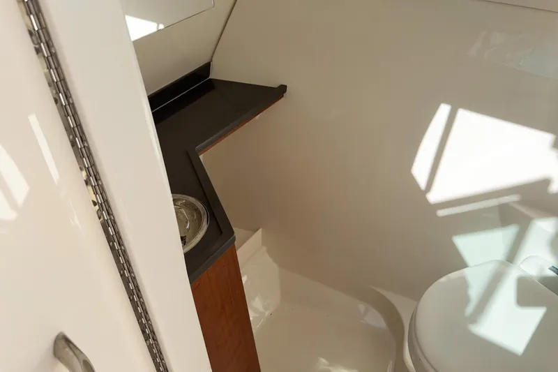 Slide: The Image of Interior of 2026 Pursuit DC 306 Dual Console boat bathroom with sink and toilet. - 17