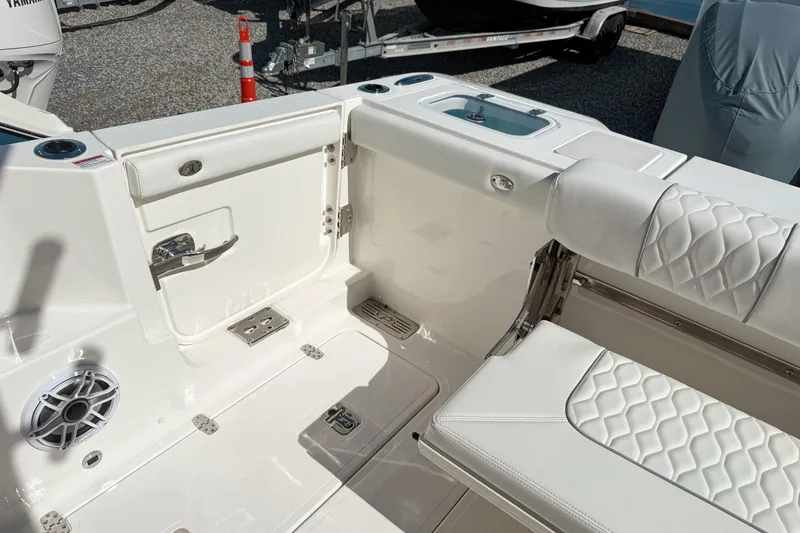 Slide: The Image of 2026 Pursuit DC 306 Dual Console boat interior with white seating and storage compartments. - 2