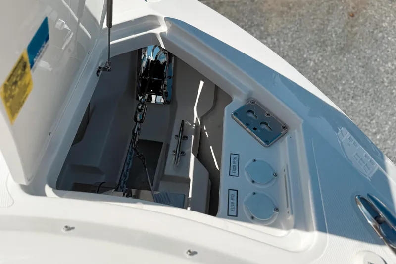 Slide: The Image of Anchor compartment of 2026 Pursuit DC 306 Dual Console boat, featuring chain and water access. - 20
