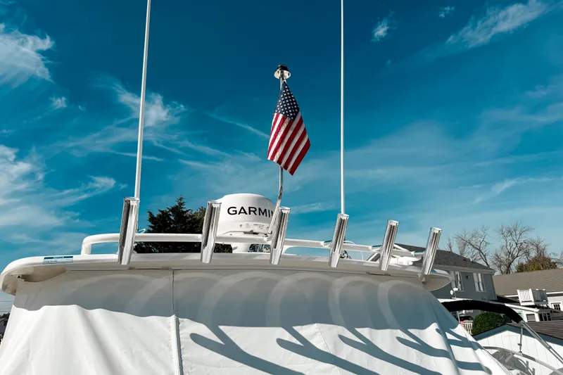 Slide: The Image of 2026 Pursuit DC 306 Dual Console boat with American flag and Garmin equipment under blue sky. - 25