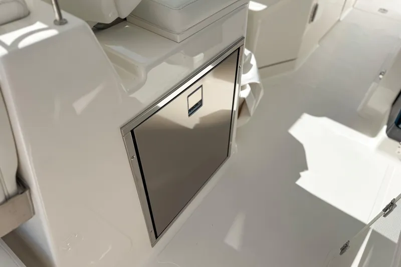 Slide: The Image of 2026 Pursuit DC 306 Dual Console interior with sleek stainless steel storage compartment. - 8