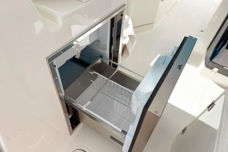 Slide: The Image of 2026 Pursuit DC 306 Dual Console boat with open storage compartment. - 9