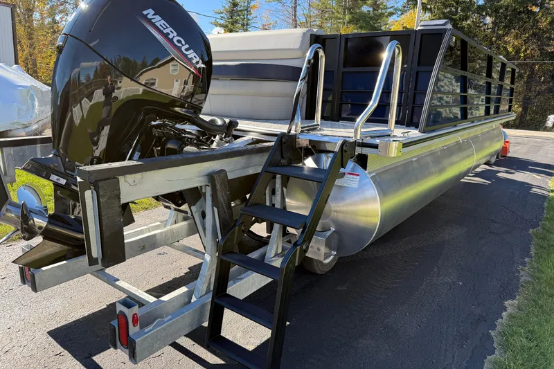 Slide: The Image of 2026 Berkshire 22 CL2 LE pontoon boat with Mercury engine, parked on asphalt. - 3