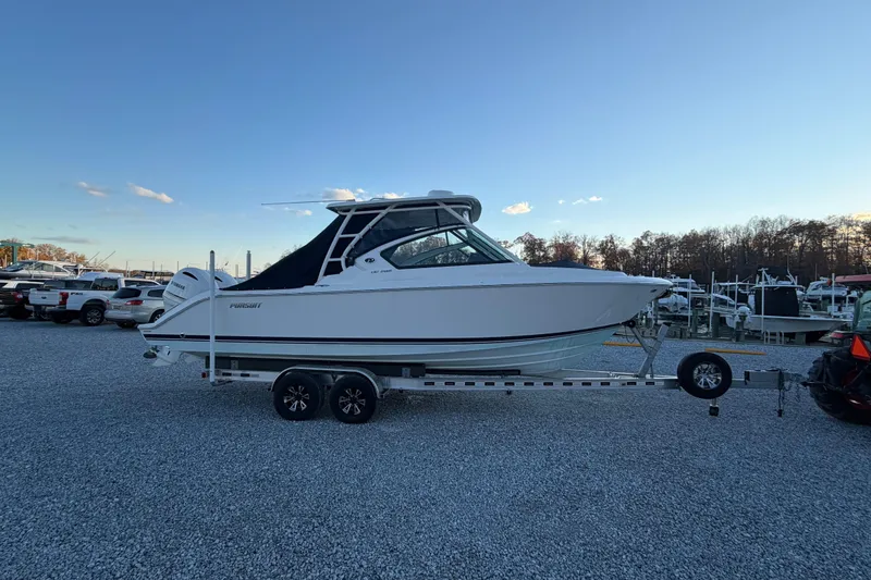 Slide: The Image of 2022 Pursuit DC 266 Dual Console boat on trailer in marina setting. - 25
