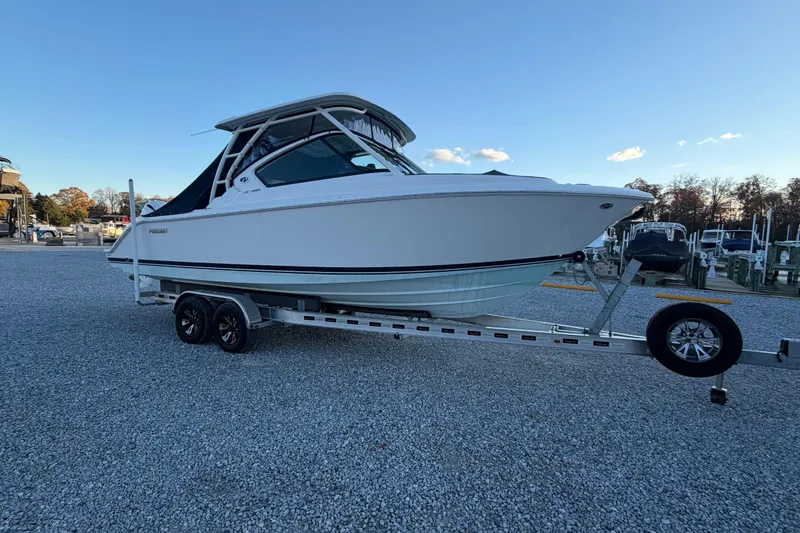 Slide: The Image of 2022 Pursuit DC 266 Dual Console boat on trailer, parked on gravel lot. - 26