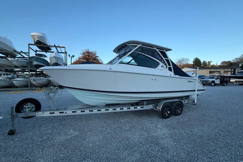 Slide: The Image of 2022 Pursuit DC 266 Dual Console boat on trailer in outdoor storage area. - 33
