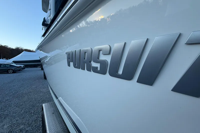 Slide: The Image of 2022 Pursuit DC 266 Dual Console boat with logo, parked outdoors. - 34