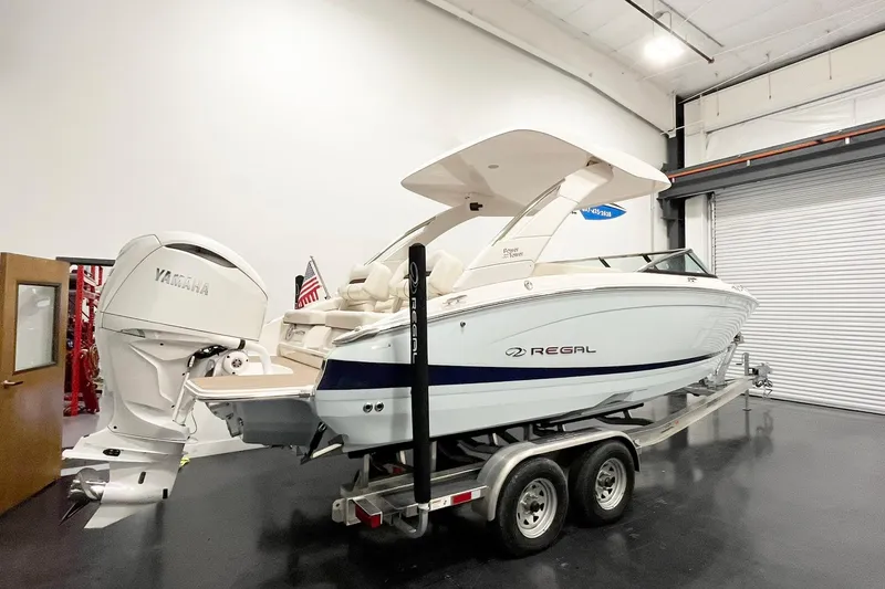 Slide: The Image of 2025 Regal LX6 boat on trailer in indoor showroom with Yamaha engine. - 4