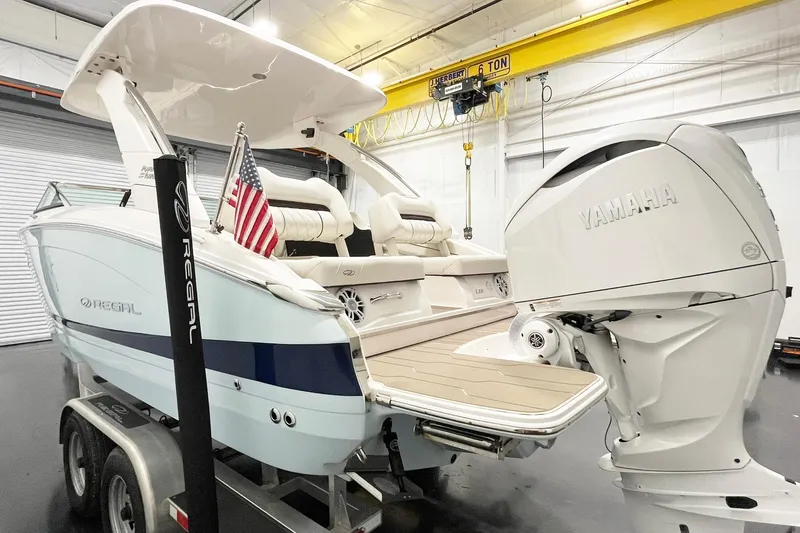 Slide: The Image of 2025 Regal LX6 boat with Yamaha engine in a showroom, featuring sleek design and American flag. - 6