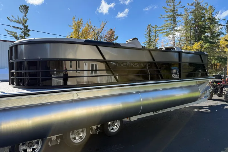 Slide: The Image of 2026 Berkshire 22 RFX LE pontoon boat on trailer, surrounded by trees and blue sky. - 6