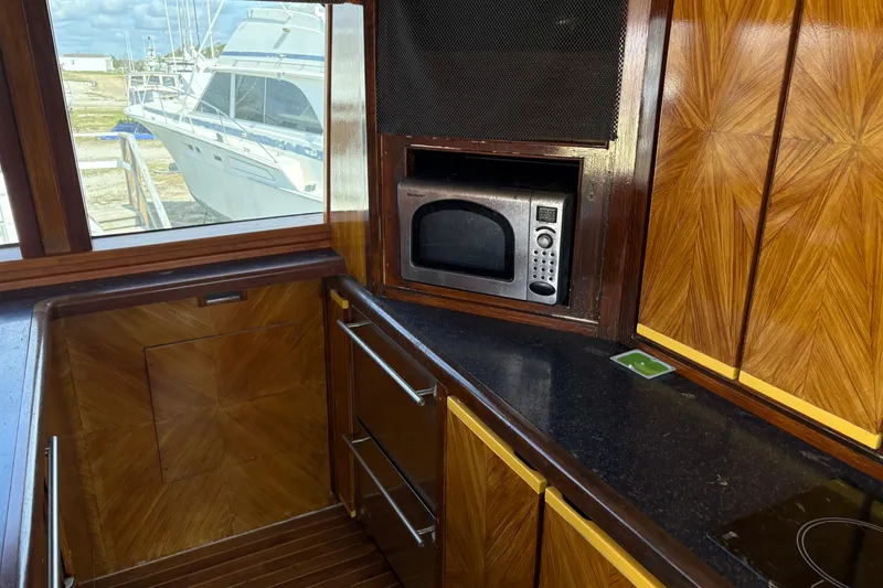Slide: The Image of Interior of 1994 Bertram 60 Convertible yacht with wood cabinetry and microwave. - 12