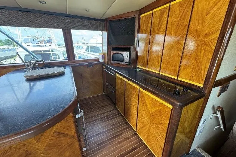 Slide: The Image of Luxurious wooden interior of a 1994 Bertram 60 Convertible yacht kitchen. - 13