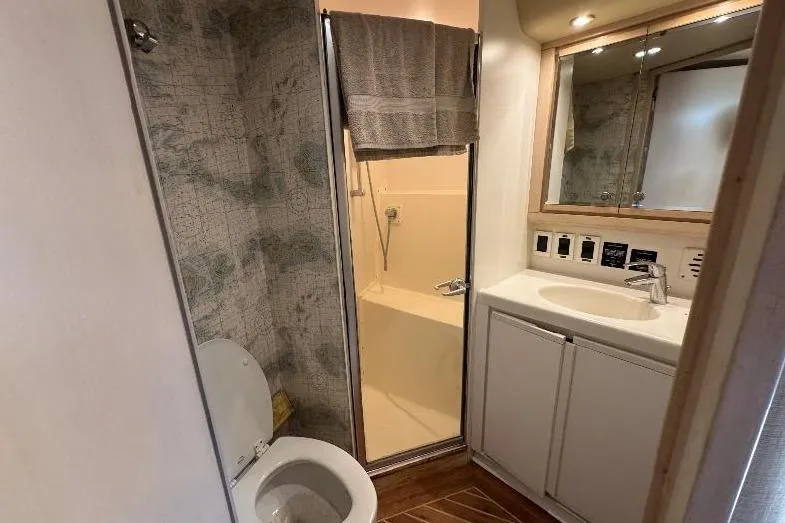 Slide: The Image of Bathroom interior of 1994 Bertram 60 Convertible yacht, featuring shower, toilet, and sink. - 17