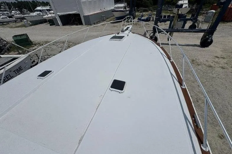 Slide: The Image of 1994 Bertram 60 Convertible yacht deck view in a boatyard setting. - 2