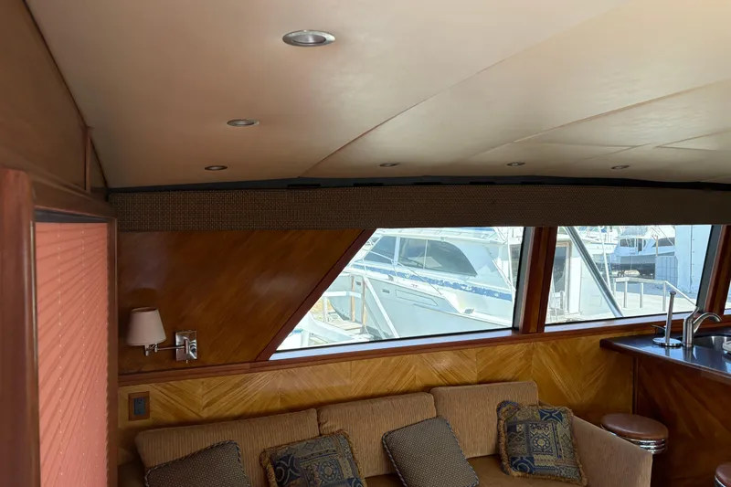 Slide: The Image of Interior of a 1994 Bertram 60 Convertible yacht with wood paneling and plush seating. - 8