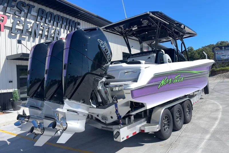 Slide: The Image of 2026 Nor-Tech 340 Sport Center Console boat with triple engines on a trailer. - 3