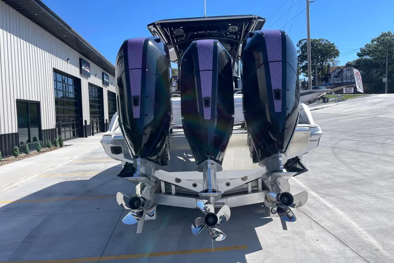 Slide: The Image of 2026 Nor-Tech 340 Sport Center Console with triple outboard engines at a marina. - 5