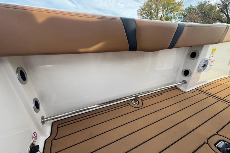 Slide: The Image of 2024 Robalo R230 Center Console boat interior with cushioned seating and teak-style flooring. - 13