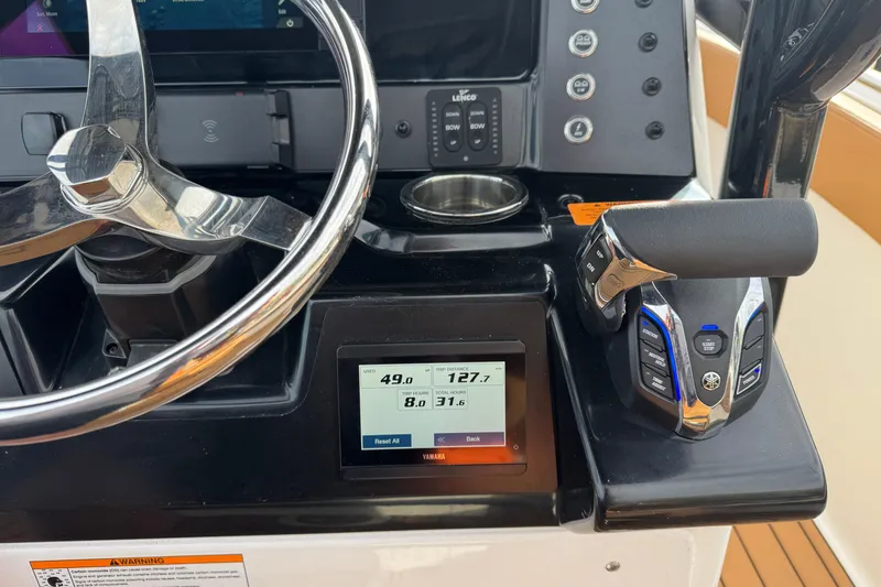 Slide: The Image of 2024 Robalo R230 Center Console helm with steering wheel and control panel. - 16