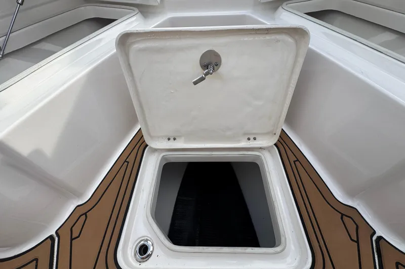 Slide: The Image of 2024 Robalo R230 Center Console storage compartment with open hatch, showcasing interior space. - 24