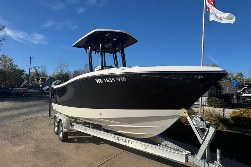 Slide: The Image of 2024 Robalo R230 Center Console boat on trailer, displayed outdoors under clear blue sky. - 3