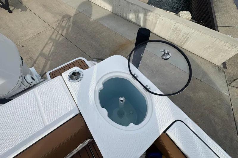 Slide: The Image of 2024 Robalo R230 Center Console boat with open livewell and seating area. - 8