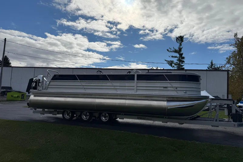 Slide: The Image of 2026 Berkshire 24 UL LE pontoon boat on trailer under cloudy sky. - 3