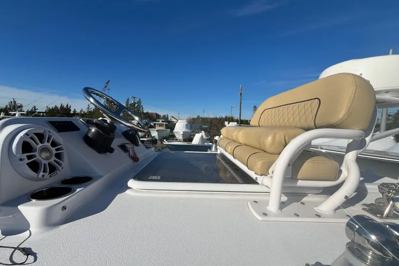 Slide: The Image of 2024 Sportsman Masters 247OE Bay Boat helm with beige seating and steering wheel. - 14