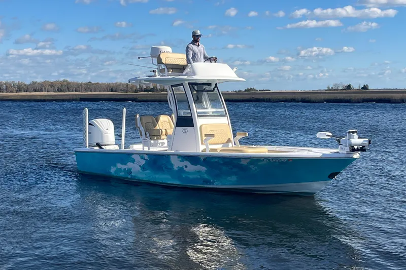 Slide: The Image of 2024 Sportsman Masters 247OE Bay Boat on water, clear sky, scenic background. - 3