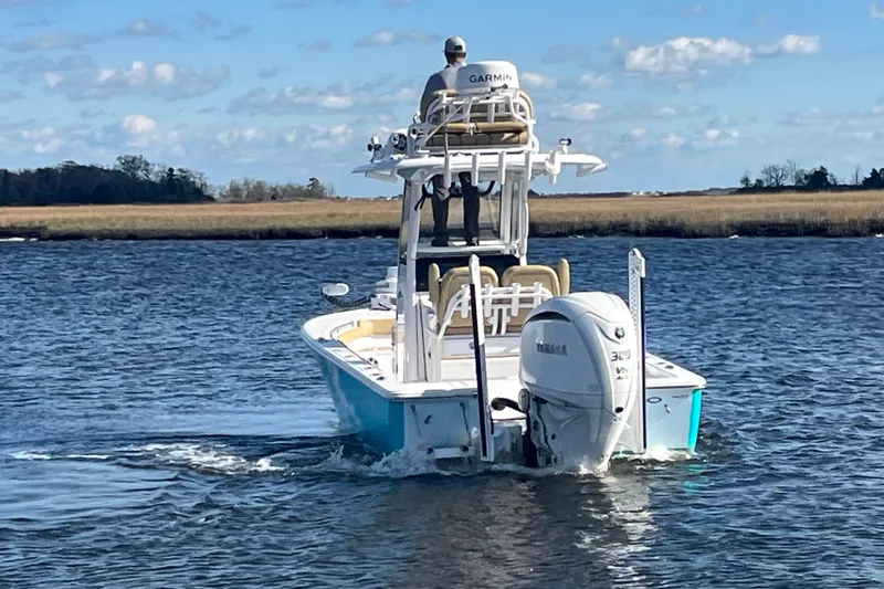 Slide: The Image of 2024 Sportsman Masters 247OE Bay Boat cruising on a calm waterway. - 7