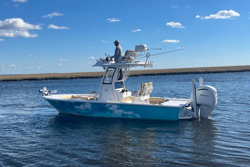 Slide: The Image of 2024 Sportsman Masters 247OE Bay Boat on calm water under blue sky. - 8