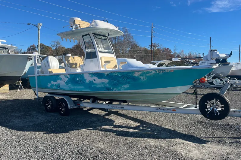 Slide: The Image of 2024 Sportsman Masters 247OE Bay Boat on trailer, vibrant blue design, parked outdoors. - 9