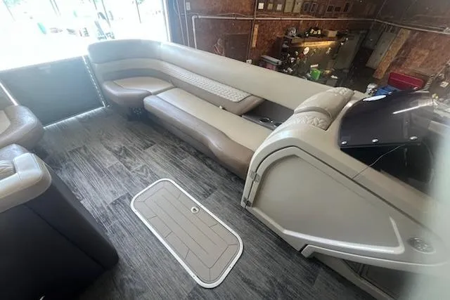 Slide: The Image of Interior of a 2020 MONACO 235C boat with beige seating and wood flooring. - 7