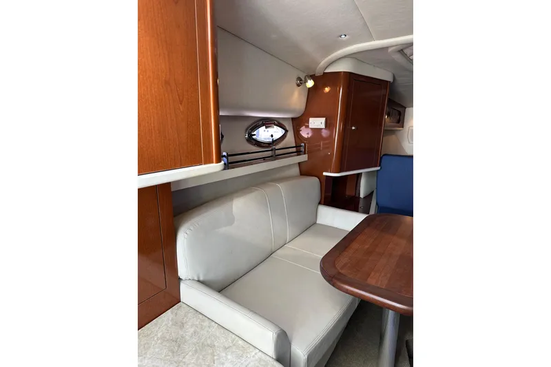 Slide: The Image of 2008 Sea Ray 290 Sundancer interior with white seating and wooden cabinetry. - 14
