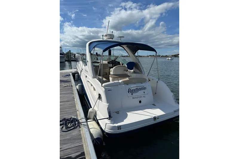 Slide: The Image of 2008 Sea Ray 290 Sundancer docked, featuring a blue canopy and white hull. - 4