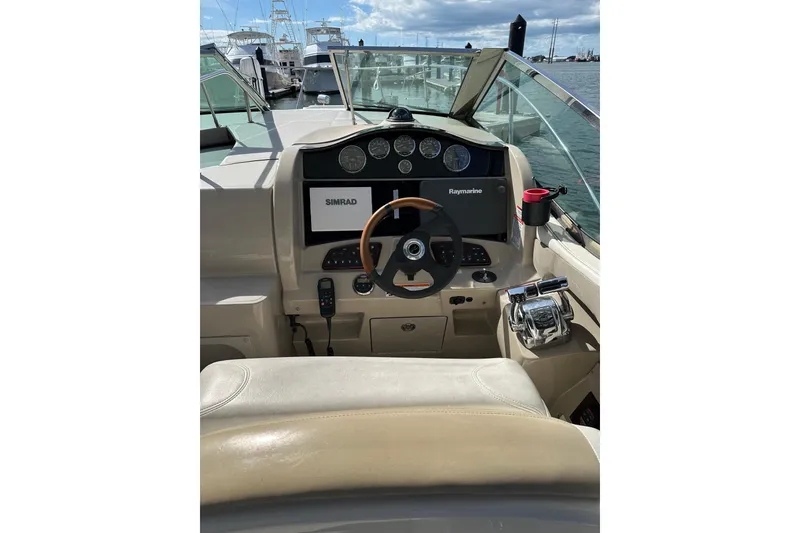Slide: The Image of 2008 Sea Ray 290 Sundancer helm with navigation equipment and steering wheel, docked at marina. - 9