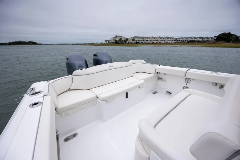 Slide: The Image of 2023 Sea Hunt Ultra 265 SE boat interior with dual engines on calm water. - 10