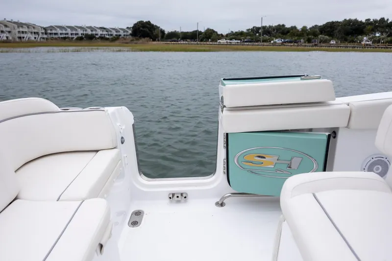 Slide: The Image of 2023 Sea Hunt Ultra 265 SE boat interior with white seating and water view. - 11
