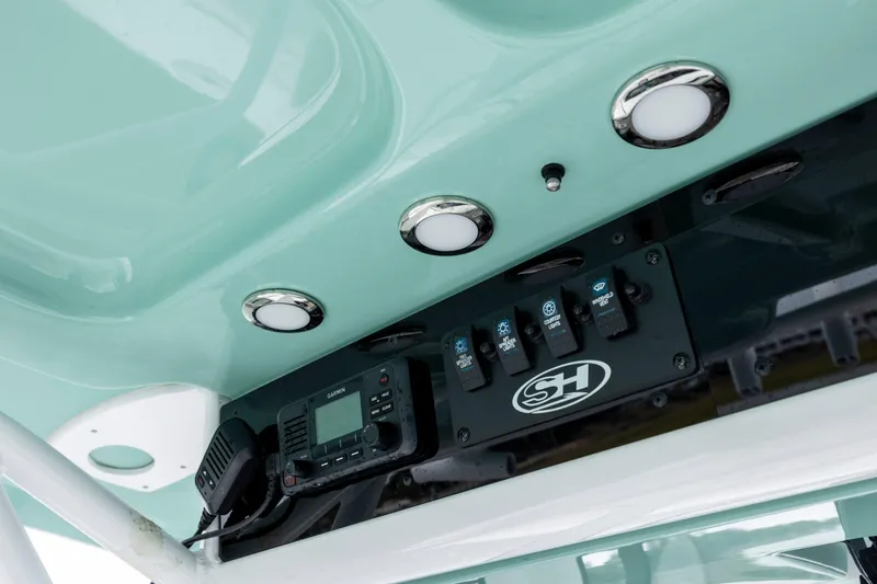 Slide: The Image of Control panel of 2023 Sea Hunt Ultra 265 SE boat with switches and radio. - 16