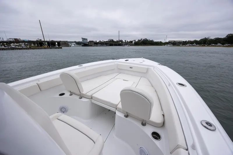 Slide: The Image of 2023 Sea Hunt Ultra 265 SE boat on calm water, featuring spacious seating. - 18