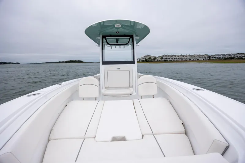 Slide: The Image of 2023 Sea Hunt Ultra 265 SE boat interior with white seating on calm water. - 20