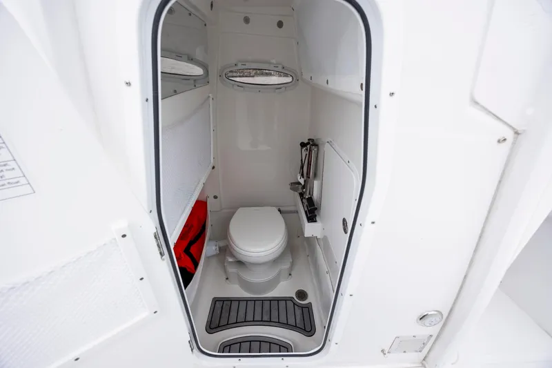 Slide: The Image of 2023 Sea Hunt Ultra 265 SE boat interior bathroom with toilet and storage. - 22