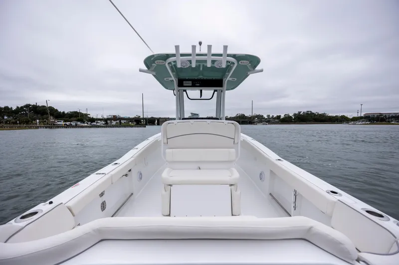 Slide: The Image of 2023 Sea Hunt Ultra 265 SE boat on calm water, showcasing spacious deck and seating. - 9