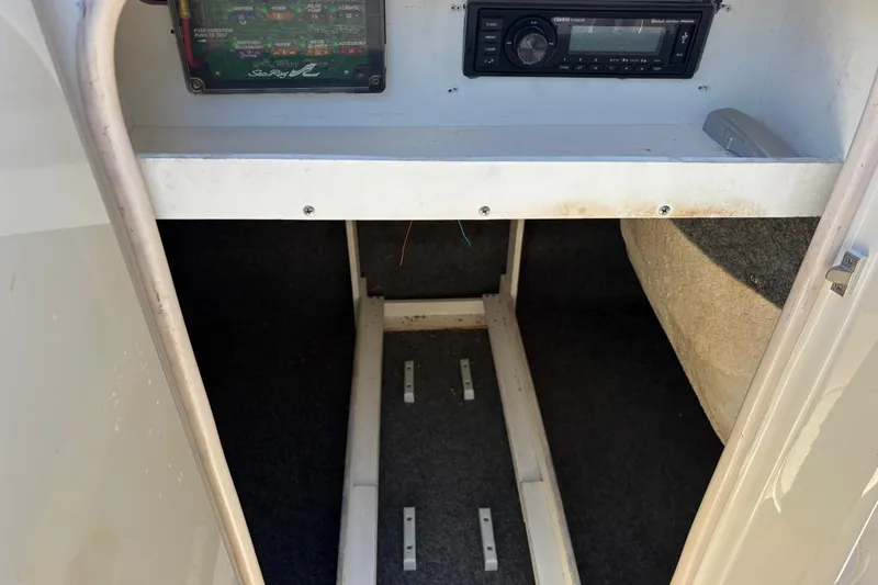 Slide: The Image of 2004 Sea Ray 240 Sundeck interior showing stereo system and storage compartment. - 15
