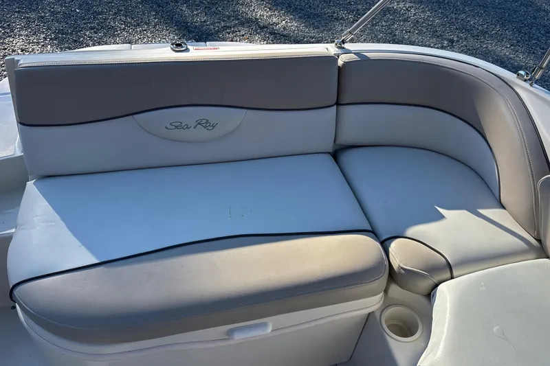 Slide: The Image of 2004 Sea Ray 240 Sundeck boat seating with beige and white upholstery. - 18