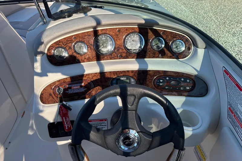 Slide: The Image of 2004 Sea Ray 240 Sundeck dashboard with gauges and steering wheel. - 19